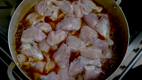 Raw-Poultry-Pieces-Being-Placed-And-Cooked-In-Boiling-Curry-Sauce-In-Pot