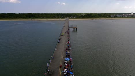 An-aerial-view-of-a-long-fishing-pier-on-Delaware-Bay-in-the-shadow-of-clouds