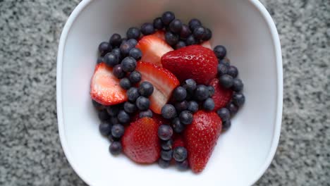 Overhead-View-Of-Sliced-Strawberries-And-Blueberries-On-The-White-Bowl