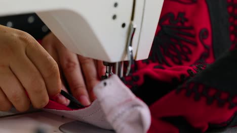 Woman-tailor-sewing-on-electric-machine-a-jacket