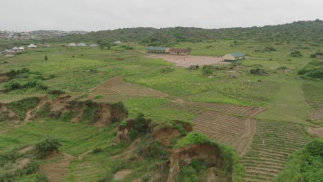 AERIAL---Village-school-and-school-yard,-Jos-Plateau,-Nigeria,-wide-forward-shot