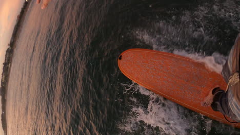 Vertikale-Aufnahme-Eines-Surfers,-Der-Auf-Einem-Surfbrett-Auf-Dem-Meer-Reitet