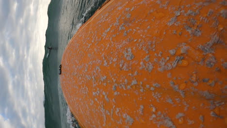 Surfer-paddling-on-board-searching-for-wave,-POV-vertical