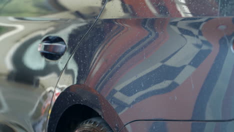 Vehicle-detail-car-wash-dryer-blowing-water-droplets-across-bodywork-panels