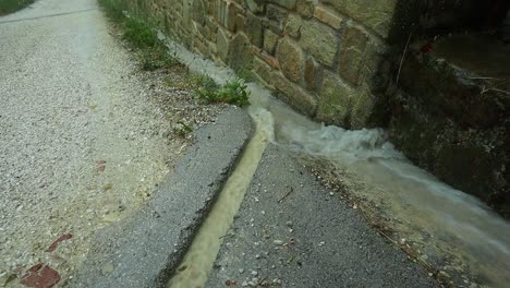 Nahaufnahme-Von-Starken-Regenfällen-Fließen-In-Die-Kanalisation,-Die-Schäden-An-Der-Straße-Verhindern