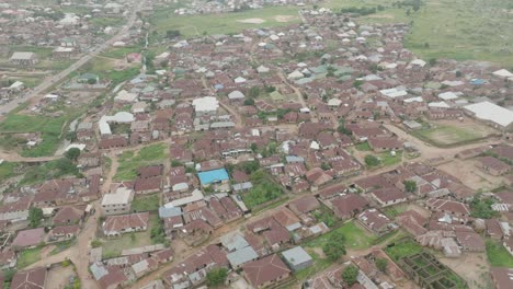 AERIAL---Cityscape-in-Jos-Plateau,-Nigeria,-forward-shot,-tilt-down,-top-down
