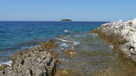 Ruhiges-Adriatisches-Meer-In-Kroatien-Mit-Insel-Im-Hintergrund-Und-Felsen-Im-Vordergrund