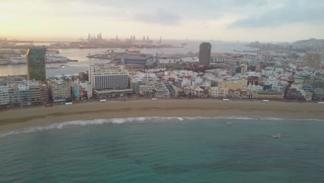 Fantastic-aerial-shot-at-dawn-over-Las-Canteras-beach-and-where-you-can-see-the-hotels,-port,-boats-in-the-area