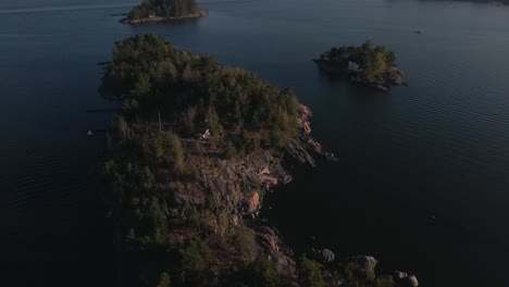 Luftaufnahmen-Von-Felsigen-Inseln-Mit-Einem-Häuschen-Im-Finnischen-Schärengarten