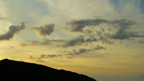 Statische-Aufnahme-Eines-Orangefarbenen-Sonnenuntergangs-Mit-Einem-Kleinen-Flugzeug,-Das-In-Den-Wolken-Verschwindet