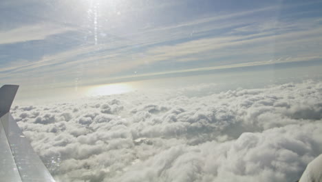 Hand-held-Footage-Out-The-Window-Of-A-Plane-Looking-Down-Onto-The-Clouds