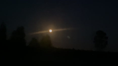 Yellow-moon-in-foreground-from-car-driving