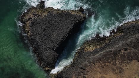 Unique-view-of-a-volcanic-rock-formation-creating-a-natural-causeway-surrounded-by-breaking-waves