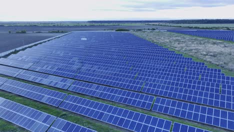Aerial-over-rows-of-solar-panels-on-vast-solar-power-plant---Racari,-Romania