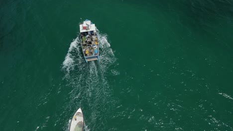Drohne,-Die-Einem-Fischerboot-Folgt,-Das-Das-Skiff-Hinter-Sich-Herzieht,-Während-Es-Sich-In-Die-Bucht-Von-Haifa-Vor-Dem-Hof-Hacarmel-Bewegt