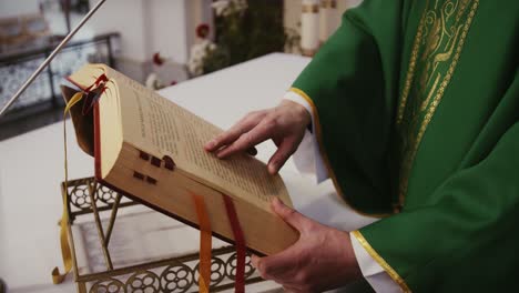 Priest-in-green-robe-is-carefully-reading-the-bible-out-loud-in-a-catholic-church