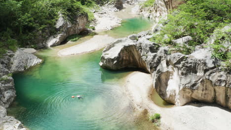 Tourist-swimming-alone-in-a-paradise-Nizao-river,-surrounded-by-wilderness
