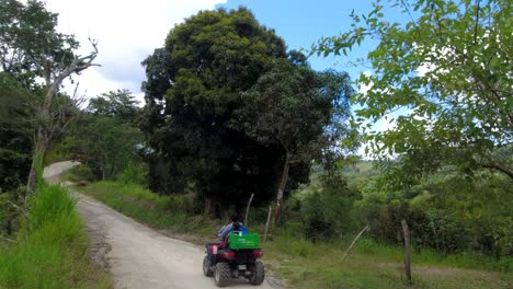 Another-shot-of-a-woman-and-a-boy-driving-in-a-rural-street-of-the-caribbean-in-a-community-called-San-Jose-de-Ocoa,-at-the-Dominican-Republic-,-the-road-is-bumpy-and-the-day-is-sunny