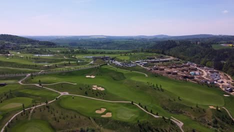 Aerial-drone-view-of-golf-course-Kacov-in-Czech-Republic,-high-panoramic-shot,-sunny-day-and-green-grass