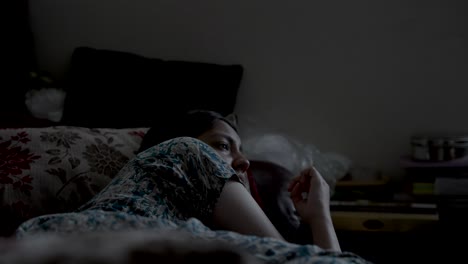 Depressed-asian-girl-lying-in-bed-in-dark-room