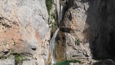 Dolly-Luftaufnahme-Eines-Exotischen-Wasserfalls-In-Den-Bergen,-Als-Wasser-Sich-In-Stein-Krümmt-Und-Einen-Teich-Bildet