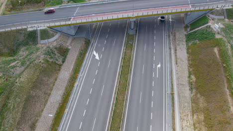 Aerial-view-of-bridge-over-highway,-flying-forward-over-lanes