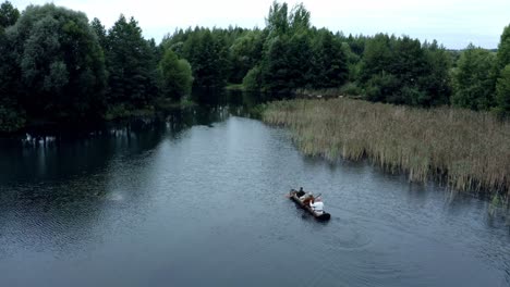 Drei-Männer-Bootfahren-In-Hölzernen-Dugots-Auf-Dem-See