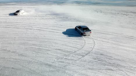 Aerial-drone-view-of-sport-car-racing-on-snow-race-track-in-winter
