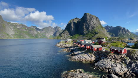 Iconic-view-in-Lofoten-with-red-small-fishing-cottages-in-the-front-and-mountains-in-the-background