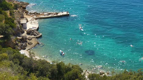 Vista-De-La-Playa-De-Croacia-Desde-Arriba-Gente-En-Paddle-Surf-Agua-Verde-Azul-Turquesa