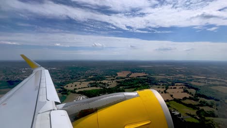 Passenger-point-of-view-of-yellow-jet-commercial-airplane-wing-and-engine-during-takeoff-from-London-Gatwick-airport
