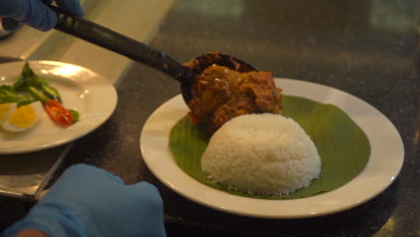 Bowel-of-rice-plating-on-banana-leaf-eggs-and-curry-dish-South-Indian-food-sides-chicken-gravy