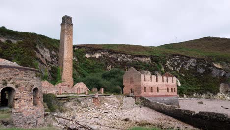 Porth-Wen-left-pan-across-abandoned-Victorian-industrial-brickwork-factory-remains-on-Anglesey-eroded-coastline