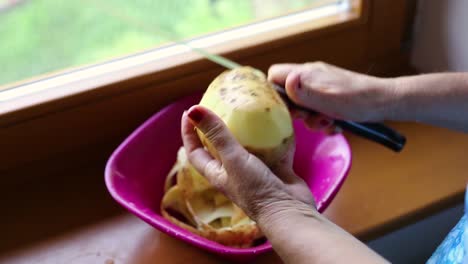 Schälen-Und-Schneiden-Sie-Die-Kartoffel-Mit-Dem-Messer-Mit-Faltigen-Händen