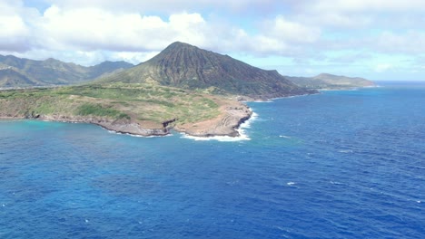 A-drone-shot-of-an-ocean-waves-splash-against-rock-on-island