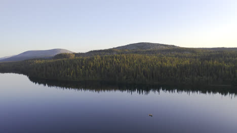 Aerial-view-of-a-calm-lake-with-people-paddling-in-a-small-canoe