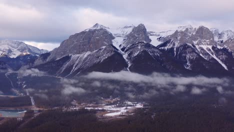 Drei-Schwesterberge-Aus-Kanadischen-Rocky-Mountains,-Einfache-Drohnenaufnahmen-Aus-Der-Luft,-Bewölkt