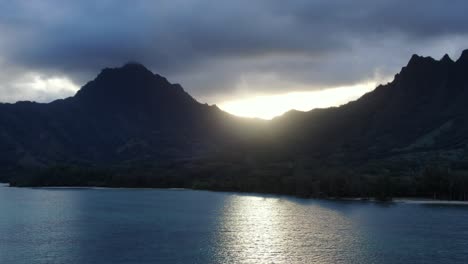 Kane'ohe-Bay-with-a-dramatic-sunset-falling-behind-the-mountain-ranges-of-Oahu-casting-a-reflection-on-the-bay