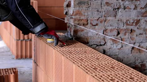 Builders-building-brick-wall-with-red-bricks-stock-footage-1