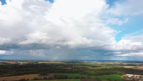 The-Rainbow-Over-the-Crop-Field-With-Blooming-Wheat,-During-Spring,-Aerial-View-Under-Heavy-Clouds-Before-Thunderstorm-7
