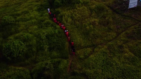Drone-shot-of-people-walking-towards-the-forest