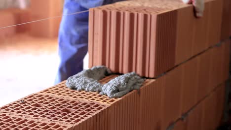 Builders-building-brick-wall-with-red-bricks-stock-footage