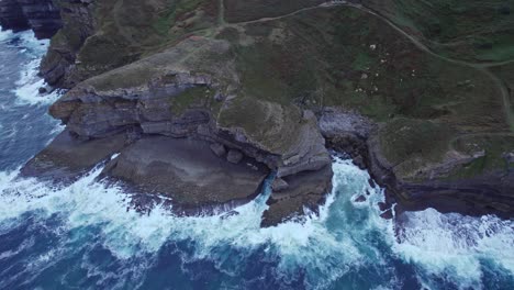 Drone-Captura-El-Borde-Rocoso-De-Isla-Isla-Donde-Las-Olas-Del-Mar-Cantábrico-Azul-Chocan