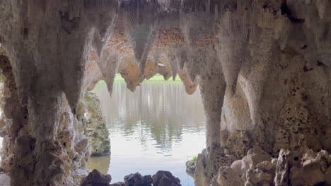 Wide-static-shot-of-a-man-made-Crystal-Cave-in-the-south-of-England,-looking-out-on-a-lake