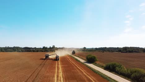 Aerial-Shot-of-Combine-Loading-Off-Corn-Grains-Into-Tractor-Trailer-2