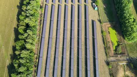 Toma-Aérea-De-Filas-De-Paneles-Solares-Utilizados-Para-Alimentar-Una-Planta-De-Procesamiento