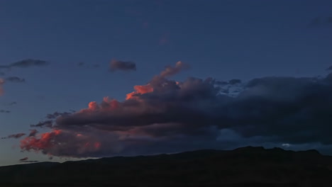 Sonnenuntergang-Beleuchtet-Wechselnde-Wolkenbildung-über-Bergrücken-Zur-Blauen-Stunde