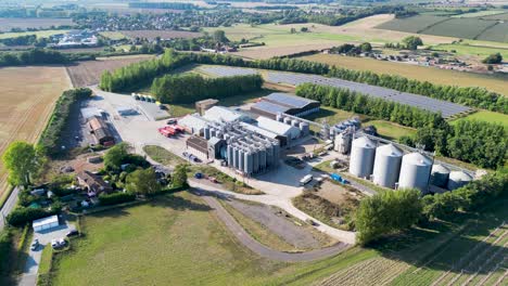 Dolly-backwards-wide-angle-view-of-a-industrial-plant-with-silos-in-the-countryside
