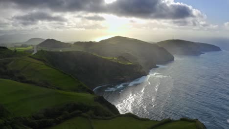 Clouds-breaking-over-grassy-coastal-cliffs-after-storm,-Azores,-aerial