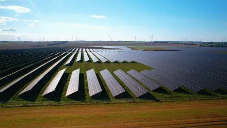 Modern-Photovoltaic-units-producing-green-energy-on-farm-field-at-sunlight---Aerial-flyover